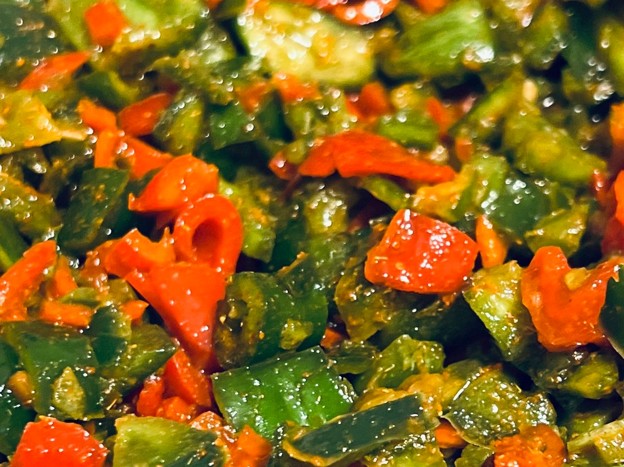Picture34 - The Canada Times Close-up of chopped green and red bell peppers sautéed in oil.