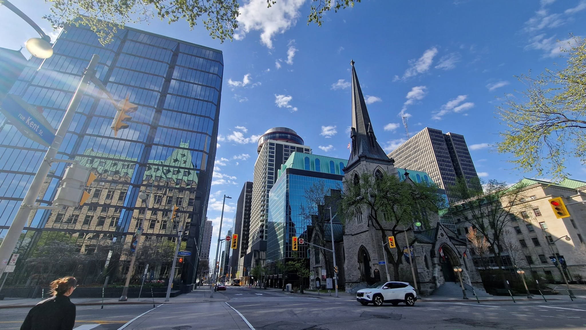 12 - The Canada Times City street with modern glass office buildings, a historic church, and blue sky with scattered clouds