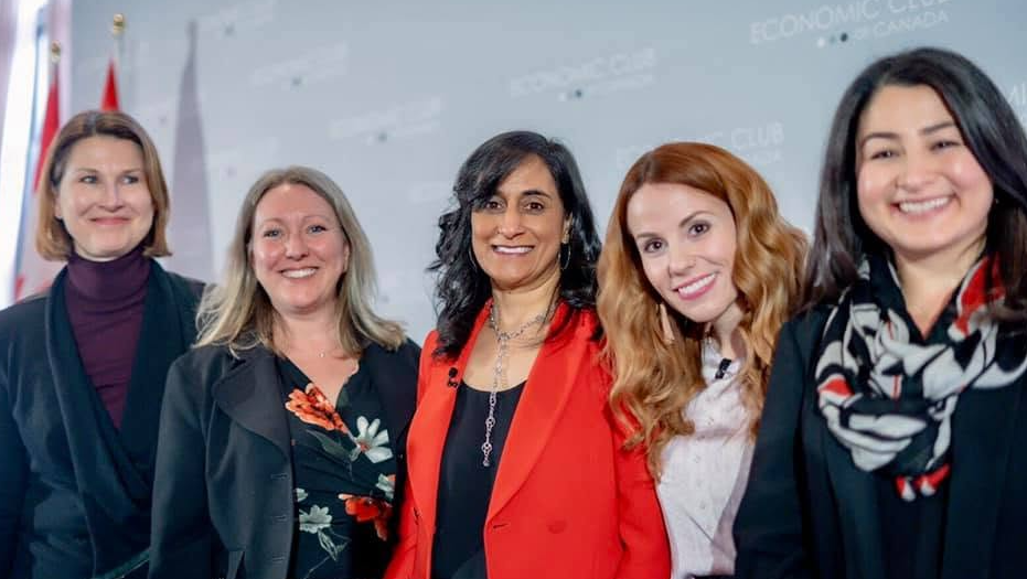 3 - The Canada Times Five women in professional attire posing together at a conference, smiling for the photo.